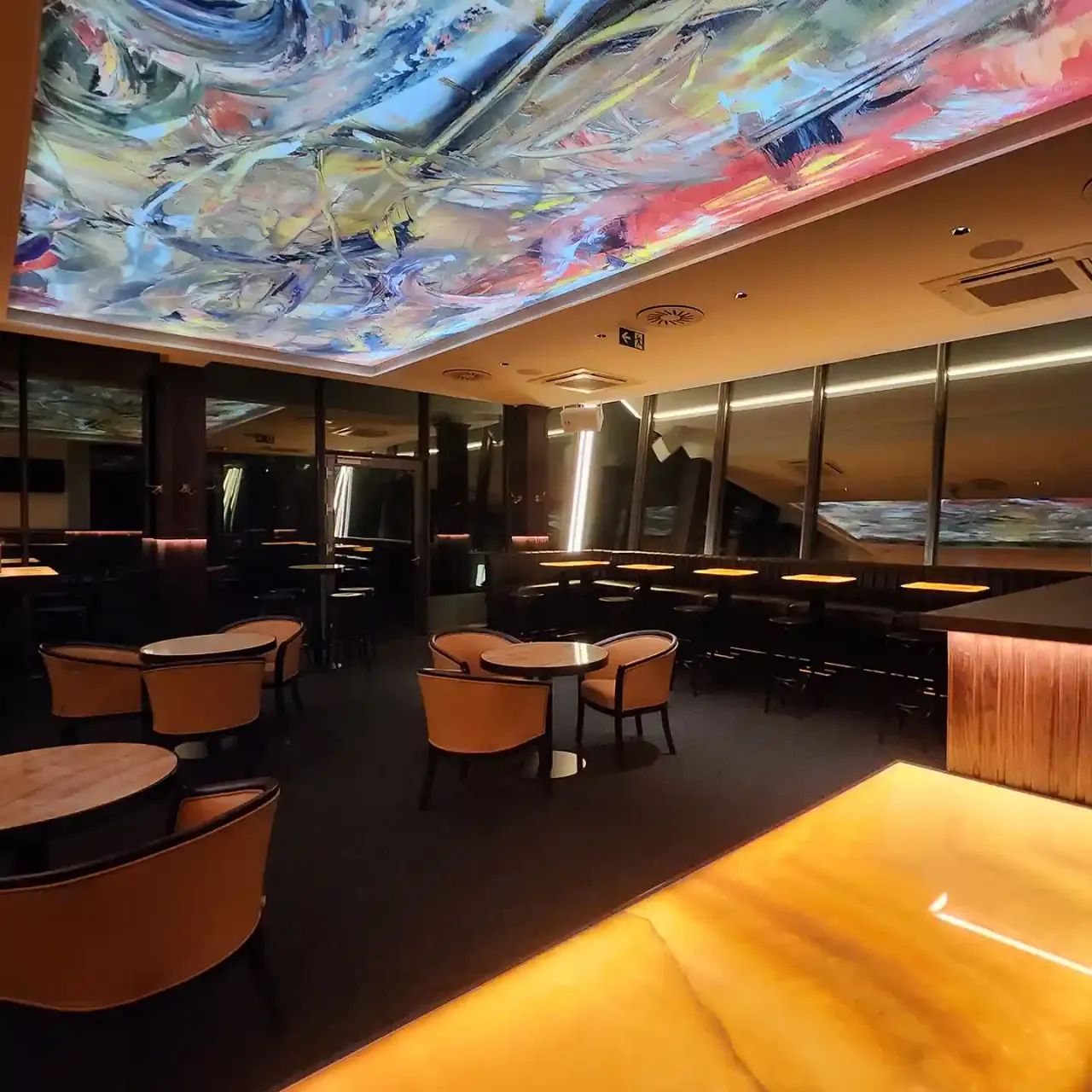 Lounge mit Kunstdecke und Sesseln im Abendlicht
