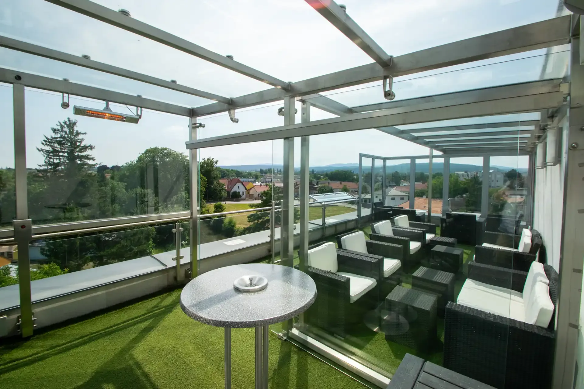 Überdachte Terrasse mit Glasdach und Rasenteppich